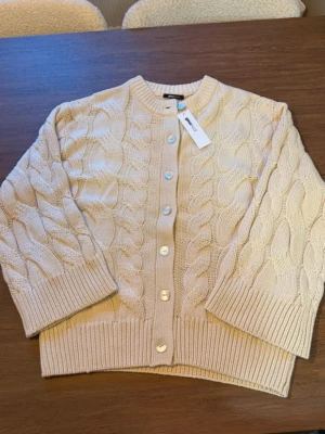 Cable knitted Cardigan  - Cable knitted cardigan från Gina Tricot med prislapp på. Storlek L då jag ville ha den oversized 🌸