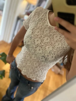 Vit spetsig topp med kort ärm - Säljer denna topp från Gina,är i bra skick säljs pga att den inte kommer till användning och pris går att diskuteras 