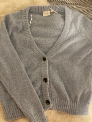 Blå stickat kofta - Säljer en blå fluffig stickad kofta från Vila i storlek S. Köpte den secondhand men har inte sett några tecken på användning. Den är inte nopprig, har kvar den ”fluffigare/ mjuka” texturen och har inga slitningar eller fläckar. Har själv bara använt 2 gånger. Skriv t mig om du är intresserad