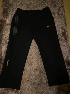 Nike NOCTA-byxor - Nike NOCTA-byxor – stilrena & bekväma 🔥  Säljer ett par snygga Nike NOCTA-byxor i mycket bra skick. Perfekta för både vardag och streetwear. Bekväma med premiumkänsla och passar till nästan allt.  Skick: Mycket bra. Enda att nämna är att en av de tre stjärnorna baktill har lossnat, så det finns två kvar. Förutom det är byxorna i fint skick