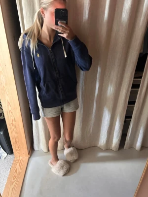 Marinblå hoodie från Polo Ralph Lauren -  En marinblå Polo Ralph Lauren sip hoodie. 