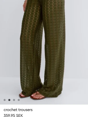 Olivgröna byxor från Gina Tricot - Säljer ett par olivgröna  från Gina Tricot i ett coolt strukturerat material. Tillverkade av 100% återvunnen polyester och har en bekväm resår i midjan. Perfekta för dig som vill ha något trendigt och miljövänligt.