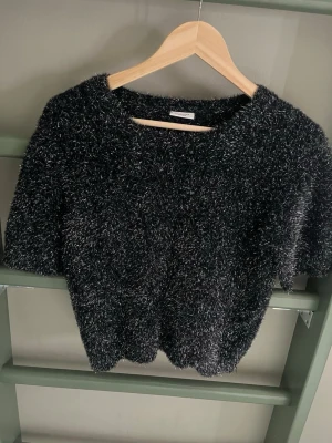 Blå fluffig stickad tröja Kappahl - Mysig blå stickad tröja från Kappahl i storlek 158/164. Tröjan har korta ärmar och är gjord i ett fluffigt, glansigt material som ger en cool look. Perfekt för dig som vill ha något både bekvämt och trendigt.