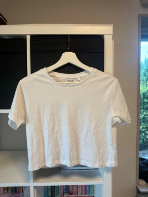 Vit croppad t-shirt från 157 - En enkel och stilren vit t-shirt från 157 i croppad modell. Funkar super att slänga över ett linne! 