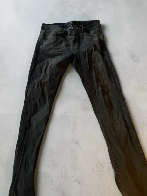 Svarta jeans från J.Lindeberg - Snygga svarta jeans från J.Lindeberg. Klassisk femficksmodell med låg midja och smal passform. Tillverkade i mjukt denimtyg som ger en skön känsla och stilren look. Perfekta för dig som gillar en slimmad siluett.