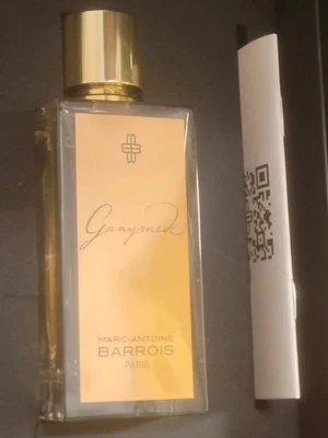 Ganymede Eau de Parfum 100ml - Lyxig parfym från Marc-Antoine Barrois, Ganymede, i en elegant rektangulär glasflaska med guldfärgat lock. Doften är Eau de Parfum och flaskan rymmer 100 ml. Stilig design med guld- och beige etikett, perfekt för dig som gillar exklusiva dofter.
