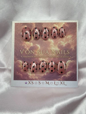 Moka (XS);ExtraShortOval  - Handgjorda press-on naglar i storlek XS: 14 mm, 11 mm, 11,5 mm, 10 mm, 8 mm. Naglarna är rosa/champange (shiftar färg vid UV)med svarta prickar och har en extra kort, oval form. Designen är lekfull och unik, perfekt för dig som vill sticka ut med dina naglar. 
