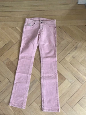 Ljusrosa raka jeans - Snygga ljusrosa jeans med rak passform och klassisk femficksdesign. Jeansen har normal midja och är tillverkade i ett mjukt denimtyg som ger en bekväm känsla. Perfekta för dig som vill sticka ut med färg i din outfit.