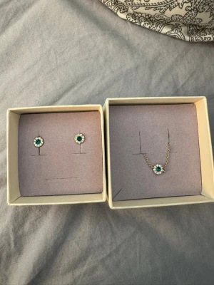 Lily and rose  - Jätte fint matchade armband och örhänge ifrån Lily and rose🥰. Fick dessa i student present men säljer då jag ej använder guld smycken. Helt oanvända🤩 det är en fin mörk grön sten i båda.