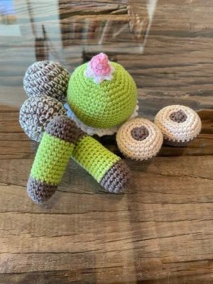 Virkade bakelser och kakor - Säljer ett set virkade bakverk som prinsessbakelse, dammsugare, ballerina och chokladbollar. Färgerna är grönt, brunt, beige och rosa. Perfekt som accessoar eller dekoration. Alla delar är handgjorda i bomull 