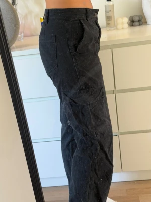 Svarta cargobyxor - Svarta cargo byxor från Pull&Bear i storlek 38, lite urtvättade annars bra skick