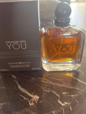 Emporio Armani Stronger With You parfym - Emporio Armani Stronger With You är en herrparfym i en elegant, fyrkantig glasflaska med rund svart kork. Doften har en varm bärnstensfärgad vätska och kommer i en stilren svart kartong. Flaskan rymmer 100 ml och har en modern, lyxig design.