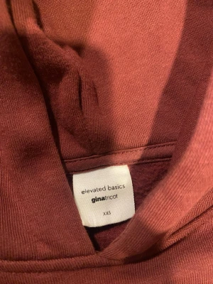 Vinröd hoodie från Gina Tricot XXS - Mysig hoodie i en  vinröd färg från Gina Tricot, modell elevated basics. Hoodien har huva, långa ärmar och ribbade muddar vid ärmslut och nederkant. Perfekt för en chill och avslappnad stil.