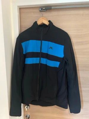 Svart golf jacka från J.Lindeberg - Snygg svart golf jacka från J.Lindeberg, perfekt för hösten/våren eller lite blåsigare dagar (funkar även som casual jacka). Använd ett fåtal gånger. Hör av er vid frågor✅