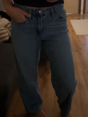 Blå baggy jeans - Säljer ett par klassiska blå jeans med rak passform och medelhög midja. Perfekta för en avslappnad och trendig look.