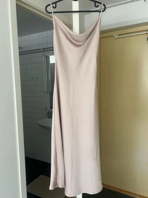 Ljusbeige satinklänning med smala band - Säljer en elegant ljusbeige satinklänning .