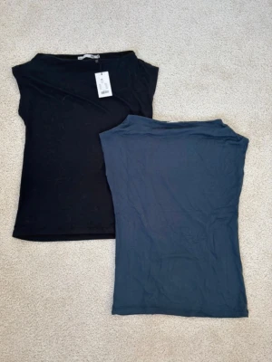 Två-pack boatneck topp - Säljer två boatneck t-shirts från lager 157 i storlek XS. Båda är oanvända men det är bara den svarta som har prislappen kvar.