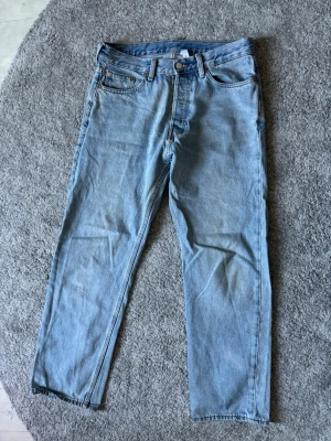 Ljusblå weekday jeans - Säljer ett par klassiska ljusblå jeans med rak passform. Jeansen har normal midja och är tillverkade i ett mjukt denimtyg. Perfekta för en avslappnad och trendig look.