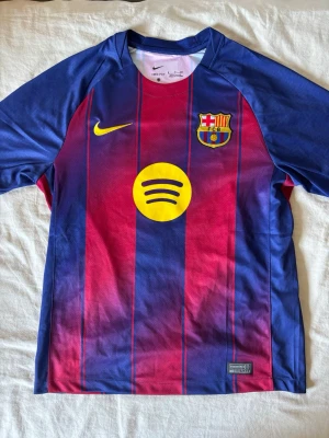 Barcelona matchtröja Pedri #8 Nike - Säljer en officiell FC Barcelona matchtröja i blått och rött med gula detaljer. Tröjan har klubbmärke, Nike-logga och Spotify som sponsor framtill samt Pedri och nummer 8 på ryggen. Tillverkad i lätt och ventilerande material, perfekt för fotbollsträning eller match.