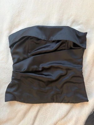 Satin tubtopp - Snygg axelbandslös tubtopp i glansigt satinliknande material❤️‍🔥❤️‍🔥❤️‍🔥 Toppen är i bra skick men fortfarande lite sliten, därav priset lägre, annars jätte fin