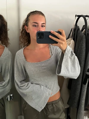 Grå croppad topp med vida ärmar - Snygg grå croppad topp med långa, vida ärmar och fyrkantig ringning. 