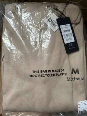 Beige hoodie från Matinique - Snygg beige hoodie från Matinique i färgen Simply Taupe. Hoodien har huva med dragsko och är tillverkad i ett mjukt material. Perfekt för en avslappnad och stilren look. Diskret logga på bröstet.