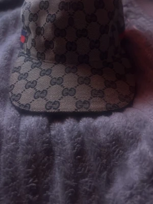 Beige keps med GG-mönster - Snygg beige keps från Gucci. Äkta keps köpt i butik men har endast kvar kepsen. Var inte rädd för att skriva och fråga!