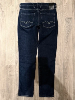 Replay Anbass Hyperflex Dry Mörkblå Jeans W29/L30 - Slim Fit - Replay Anbass Hyperflex Dry mörkblå jeans med slim fit-passform som sitter smalt och bekvämt och funkar till allt, storlek W29/L30, midja 36,5 cm, ytterbenslängd 100 cm, benöppning 15 cm, modellen är 185cm & väger 65kg, i fint skick.