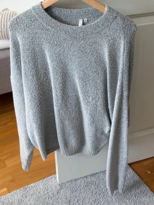 Ljusgrå stickad tröja NLY Trend - Mysig ljusgrå stickad tröja från NLY Trend i storlek M. Tröjan har rund halsringning, långa ärmar och ribbade muddar. Perfekt för lager på lager och chill dagar. Materialet känns mjukt och fluffigt.