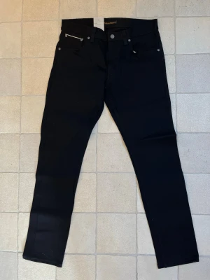 HELT NYA Selvage jeans ifrån Nudie Jeans  - Säljer ett par HELT NYA svarta Dry black Selvage jeans ifrån Nudie Jeans i storleken 32-32! Modellen är Lean Dean! 🤩✌🏼——————————————————————————📐| Storlek: 32-32                                                   👖| Märke: Replay                                                   🔎| Skick: HELT NYA!                                              💵| Ny Pris: 2500kr                                                   ✍🏻| Skriv om du har några frågor