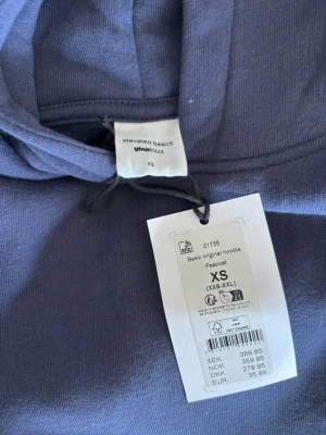 Mörkblå hoodie från Gina - Mörkblå hoodie från elevated basics i storlek XS. Klassisk modell med huva och magficka, ribbade muddar vid ärmslut och nederkant. Tillverkad i mjukt bomullsmaterial! Helt ny med prislapp!💞