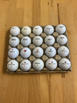 Samling med 20 vita golfbollar 3 Nike och resten är Wilson  - Säljer ett set med 20 vita golfbollar från olika märken som Wilson, Nike och Ultra. Bollarna har klassisk dimple-design och levereras i en praktisk kartongbricka. Perfekt för dig som vill fylla på golfbagen inför nästa säsong.