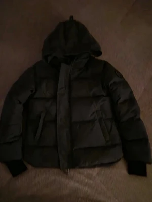Canada goose black label macmillan - Säljer en grå pufferjacka från Canada Goose Macmillan, modell Fusion M/M. Jackan har huva, ribbade muddar och black label logotyp på ärmen. Materialet är slitstark polyester och jackan har dragkedja framtill. Perfekt för kalla dagar och har en clean, modern look taggar och sånt som jag fick med finns kvar och den är som ny. Pris kan diskuteras och om ni har några frågor så är det och ställa dem 😁😁😁