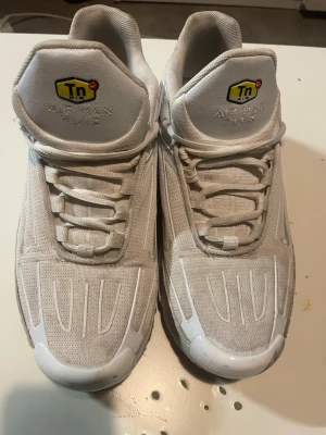 Nike Air Max Plus vita sneakers - Nike Air Max Plus sneakers i helvitt med mesh- och syntetmaterial. Klassisk Tn-logga på plösen och synlig Air Max-dämpning i sulan. Snygg, sportig design med vita detaljer och robust yttersula. Perfekta för dig som gillar streetwear och vill ha en clean look.