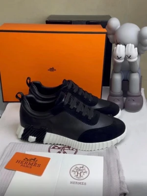 Svarta sneakers - Snygga svarta sneakers med en mix av mocka och läder. Skorna har vita, räfflade sulor och svarta detaljer på hälen. Klassisk snörning och diskret logga. Perfekta för dig som gillar stilrena och exklusiva sneakers.