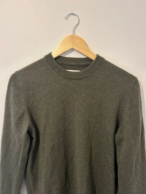 Mörkgrön stickad tröja Samsøe Samsøe - Mysig mörkgrå stickad tröja från Samsøe Samsøe med rund halsringning och långa ärmar. Tröjan har en enkel och stilren design, perfekt för lager på lager och passar till det mesta. Materialet känns mjukt och bekvämt.