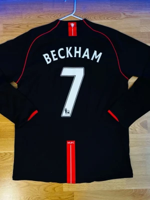 Manchester United 2007 Retro Beckham matchtröja - Säljer en svart Manchester United matchtröja från 2007, den ikoniska långärmade tröjan från Nike med AIG som huvudsponsor. Beckham som är Uniteds största ikon och den snyggaste matchtröjan (även om han ej spelade där 2007), hyllning till Beckham. ✨ Helt ny, aldrig använd, aldrig tvättad. ✨Tröjan är XXL, men snygg att bära om man är under 1.90 cm, som oversized jersey! ✨