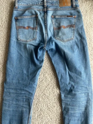 Nudie Jeans Lean Dean - Tja, säljer ett par ljusblå Nudie jeans i modellen Lean Dean. Färgen heter ”Lost orange” och de är i storlek 31/34. De är i mycket bra skick, inte använt särskilt ofta. Skriv om ni har frågor om mått eller liknande