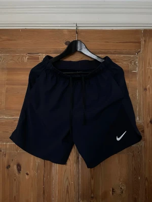 Nike Miller shorts - Nike Shorts – Marinblå   Säljer ett par snygga Nike shorts i marinblå färg, storlek S. Perfekta till träning, fotboll, gym eller bara till vardags.  Mycket bra skick – inga större märken eller skador. Färg: Marinblå 📏 Storlek: S 🏷️ Märke: Nike 📦 Kan skickas med post  Skickar snabbt och packar ordentligt. Hör av dig vid intresse eller om du har några frågor!  
