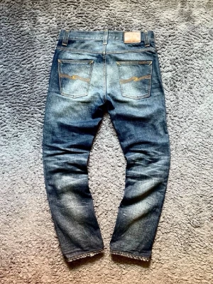 Nudie jeans - Säljer ett par riktigt feta Nudie Jeans!! Skick: 10/10! Knappt använda! Storlek: 30W 32L Model: Grim Tim! Väldigt snygg blandning av marinblå och grå! Hör av er vid minsta fundering!! ☁️