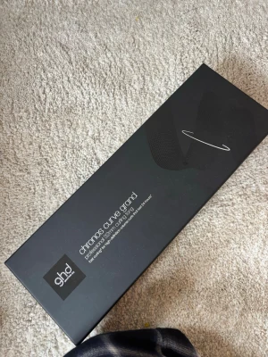 ghd Curve Grand locktång svart - Säljer en svart ghd Curve Grand locktång i originalförpackning. Locktången har en elegant design med rundad form och lång sladd, perfekt för att skapa stora, mjuka lockar. Kommer i en stilren svart låda.