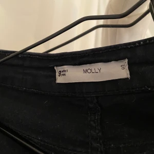 Svarta Molly jeans  - Svarta Molly jeans ifrån ginatricot, dem är väldigt använda och är i okej skick, dem har några små hål på ena fickan, och jag har klippt av dem en bit eftersom att dem var för långa för mig! Nypris : 300 kr! 