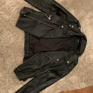 Skinnjacka svart storlek 36 - Väldigt fin och snygg skinnjacka från Gina Tricot finns inte kvar i butik eller på deras hemsida. Den är lite sliten vi kragen som kan se men det är inget man ser när man har på den. 