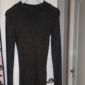 Glitterklänning  - Svart glitterklänning med glitter av guldfärg (strl S). Köpt från Kappahl och använt denna 2 gånger.