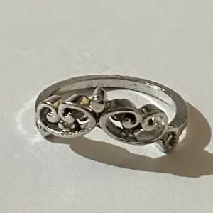 Silverring med små detaljer i form av en krona.