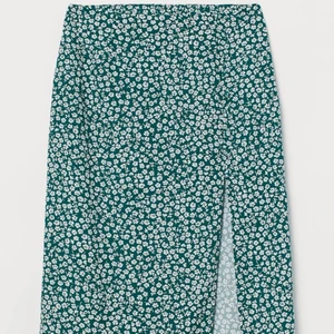 Grönblommig kjol  - Jättefin Grön och vitblommig sommarkjol från HM. Slits och knappar. Oanvänd, storlek 34, slutsåld. 70+frakt