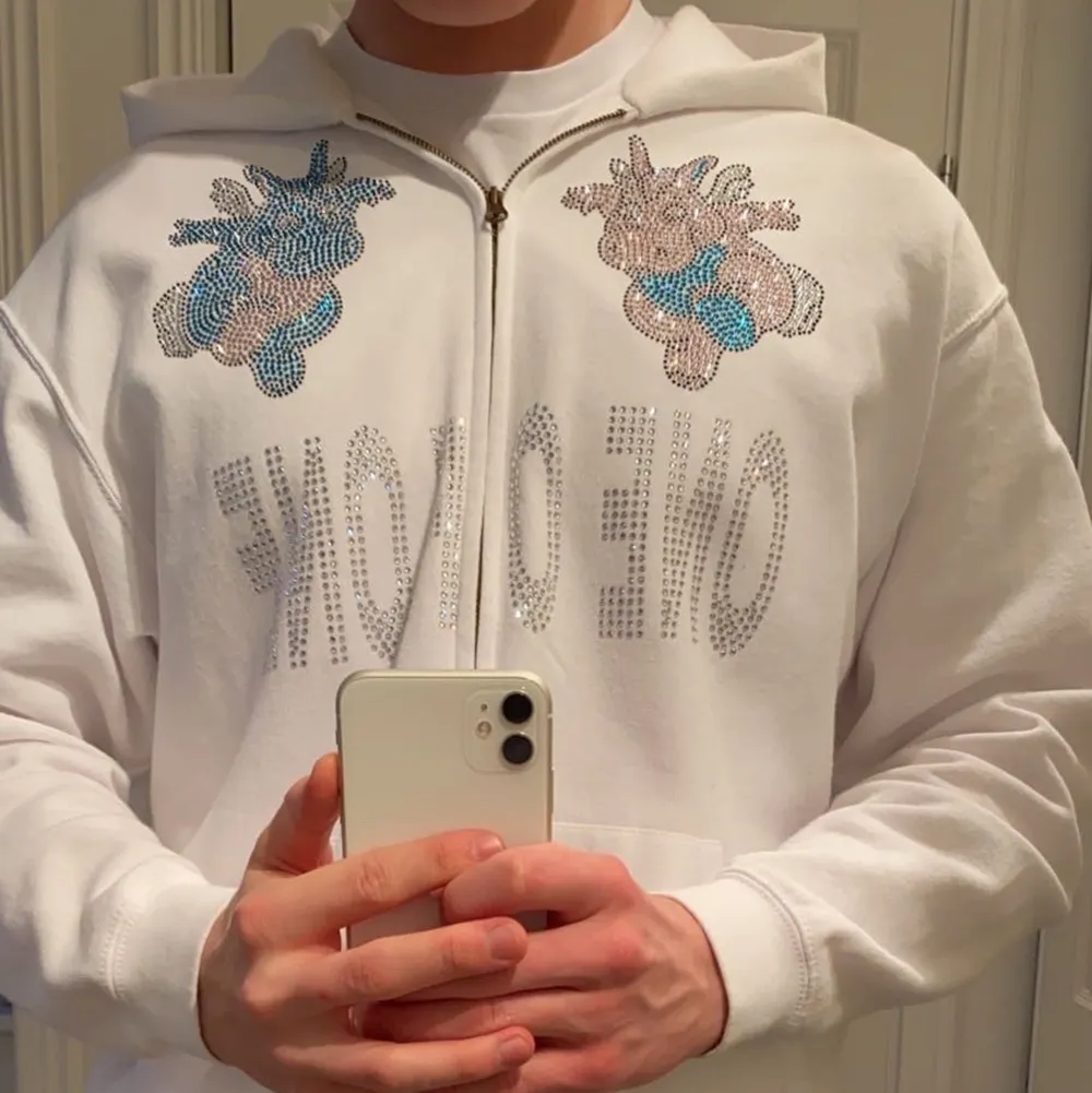 Säljer denna vita One Of One hoodie med Rhinestone på grund av att den inte kommer till användning längre. Är 182 cm och väger runt 80 kg och L sitter bra på mig. Väldigt bra skick, dock har sömmen gått upp pyttelite på vänstra ärm mudden. . Tröjor & Koftor.