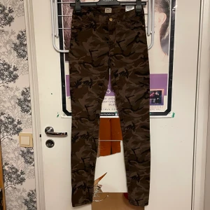 Jeans - Jeans med camouflage mönster. Fickor bak men inte fram. Hund finns i hemmet!
