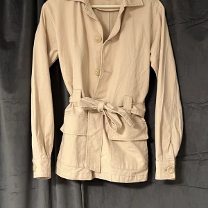 Kappa - En beige kappa grå. Nelly köpt för ganska länge sen men inte använd många gånger inga skador eller hål den går presis över rumpan och om du har några frågor kak du skriva till mig om du vill ha mer bilder på den tex🥰kan gå ner i pris vid snabb affär