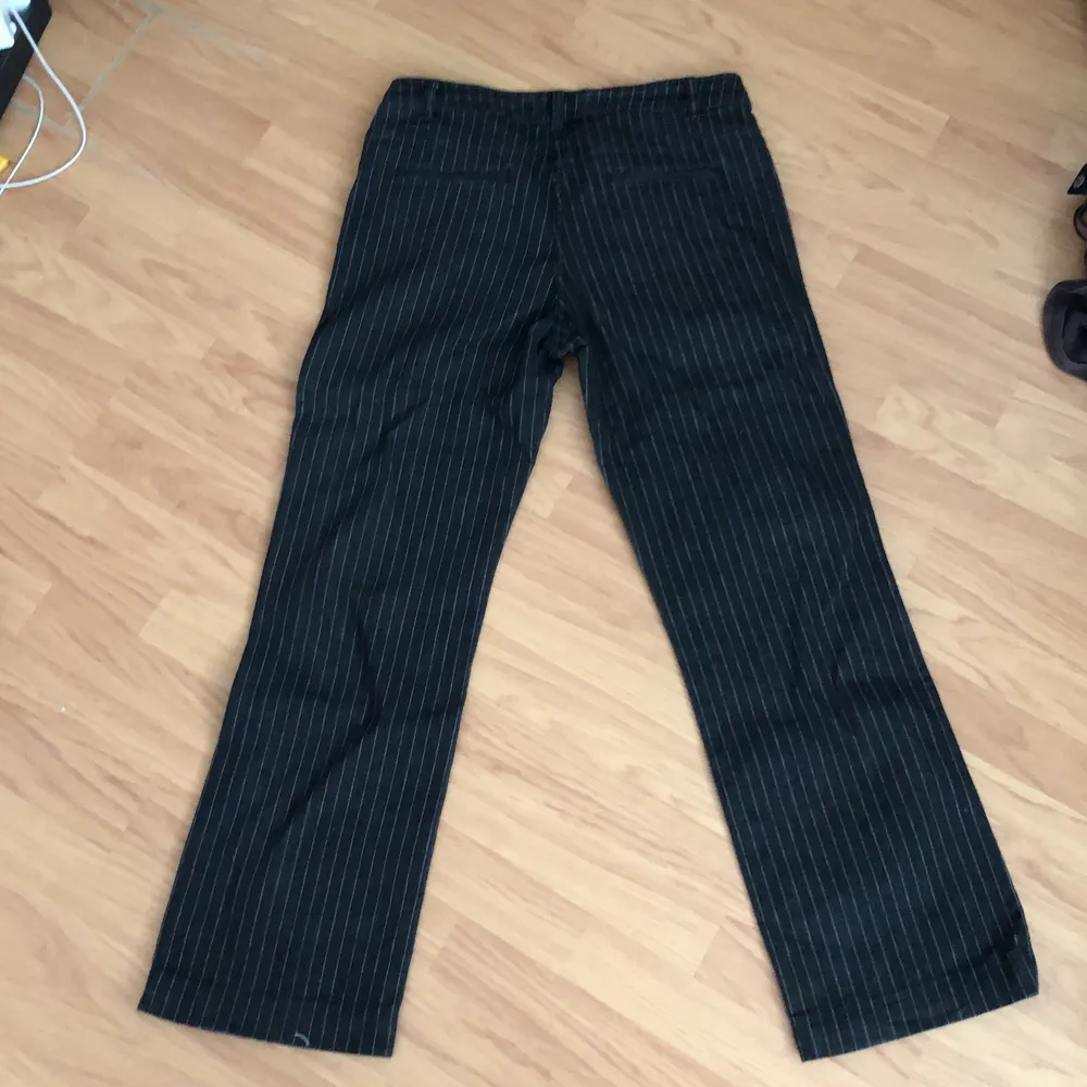 snygga lågmidjade svarta jeans med vita ränder i storlek 44 men sitter som M, köparen står för frakt💚. Jeans & Byxor.